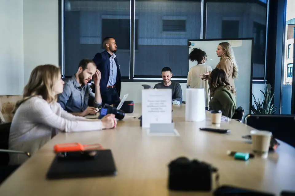 Team meeting in a conference room with a presenter at a screen