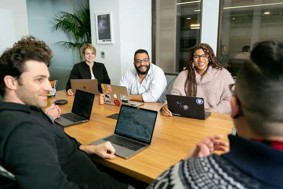 Small team working together around a table with laptops